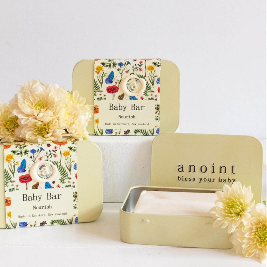 Three of the Anoint Baby Bar in tins in a staged shot