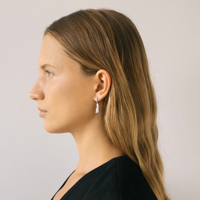 Nina Gordon Solo Tag Sleeper Hoop Earrings in Silver on a model