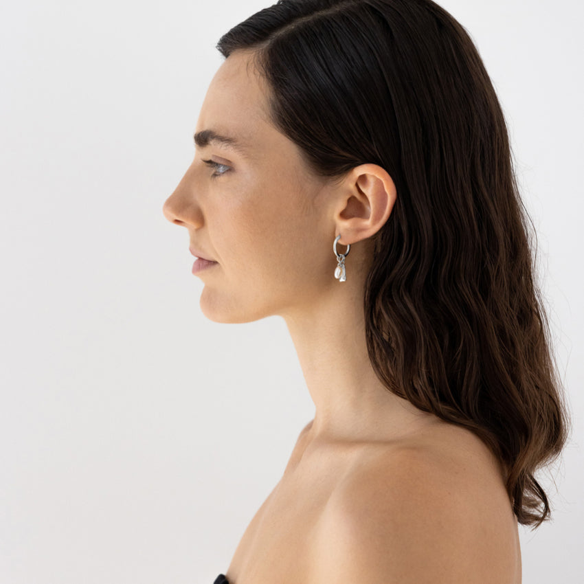 The Nina Gordon Tag Sleeper Hoops in Silver on a model