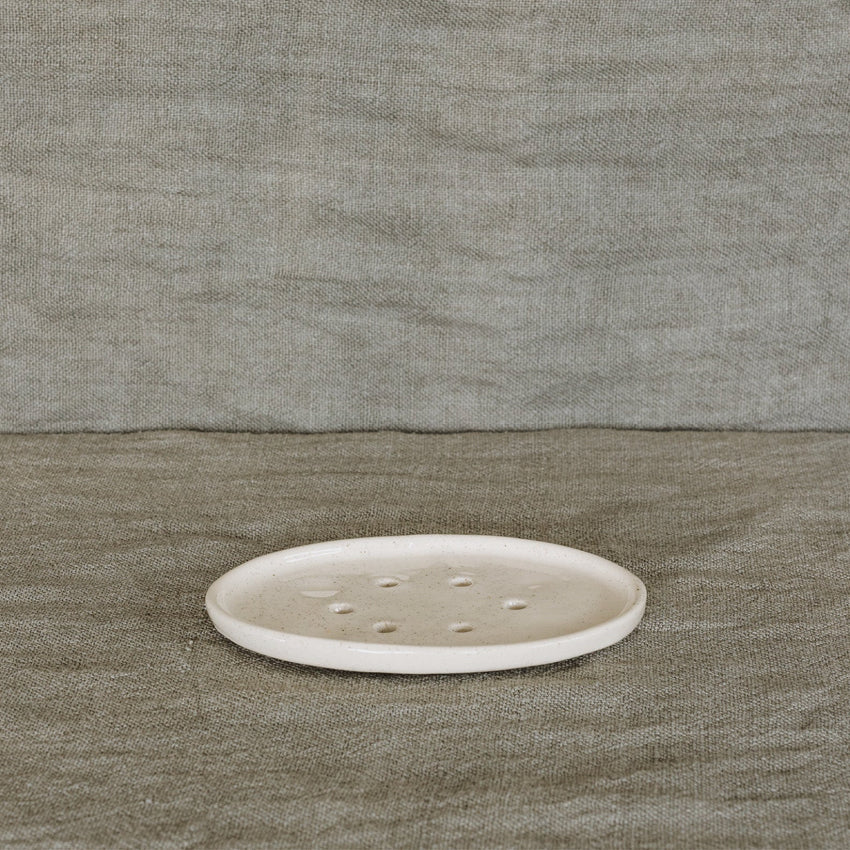 The JS Ceramics Soap Dish in Oatmeal on a green linen backdrop