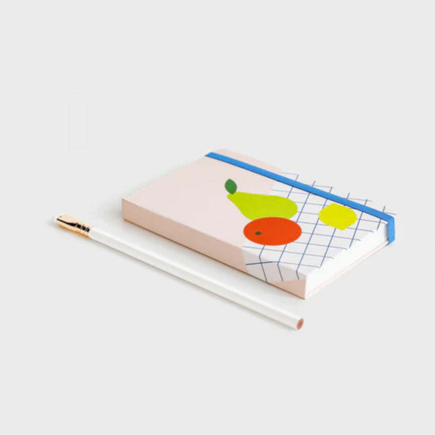The Lettuce Fruit Picnic Notebook on a blank background next to a pencil