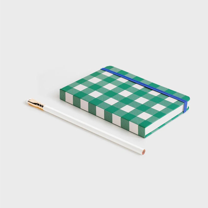 The Lettuce Picnic Hardcover Notebook on a blank background next to a pencil