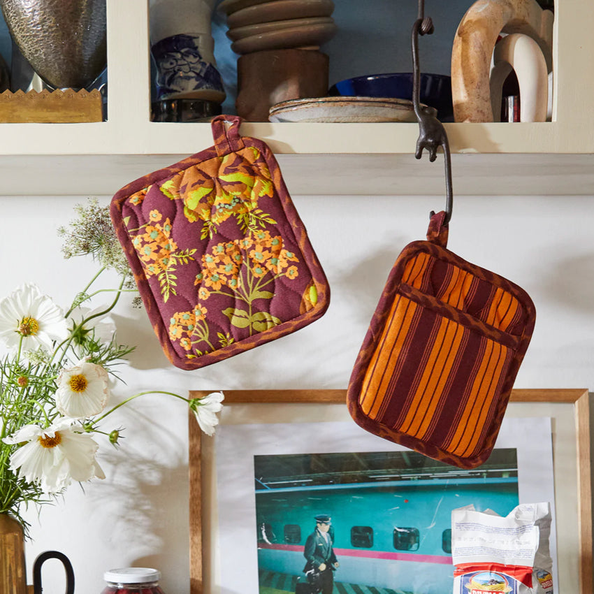 The Sage x Clare Margot Pot Holder Set hanging in a kitchen