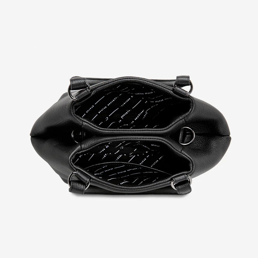 A top view of the Status Anxiety Astral Bag in Black open on a blank background
