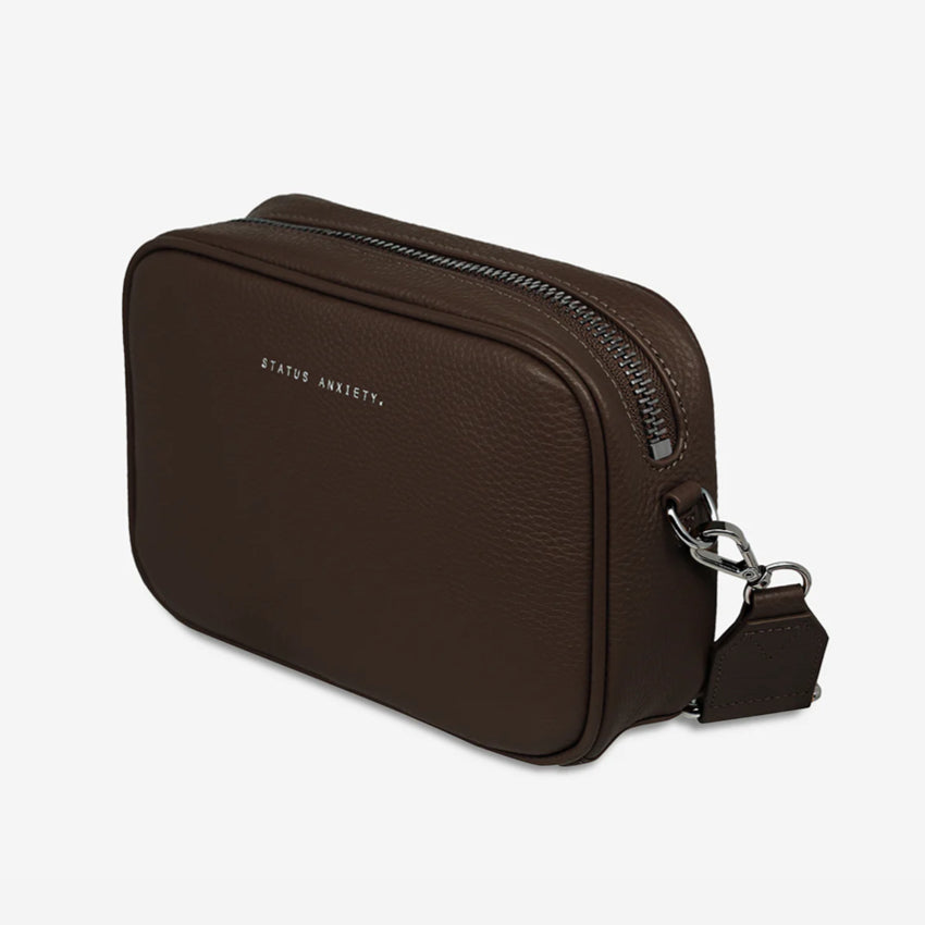 The side profile of the Status Anxiety Plunder Bag with Webbed Strap in Cocoa on a blank background