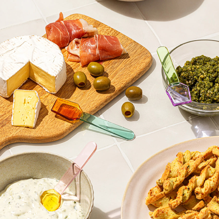 The Sucker Glass Spoon Set in dips and on a cheese board on a tiled bench
