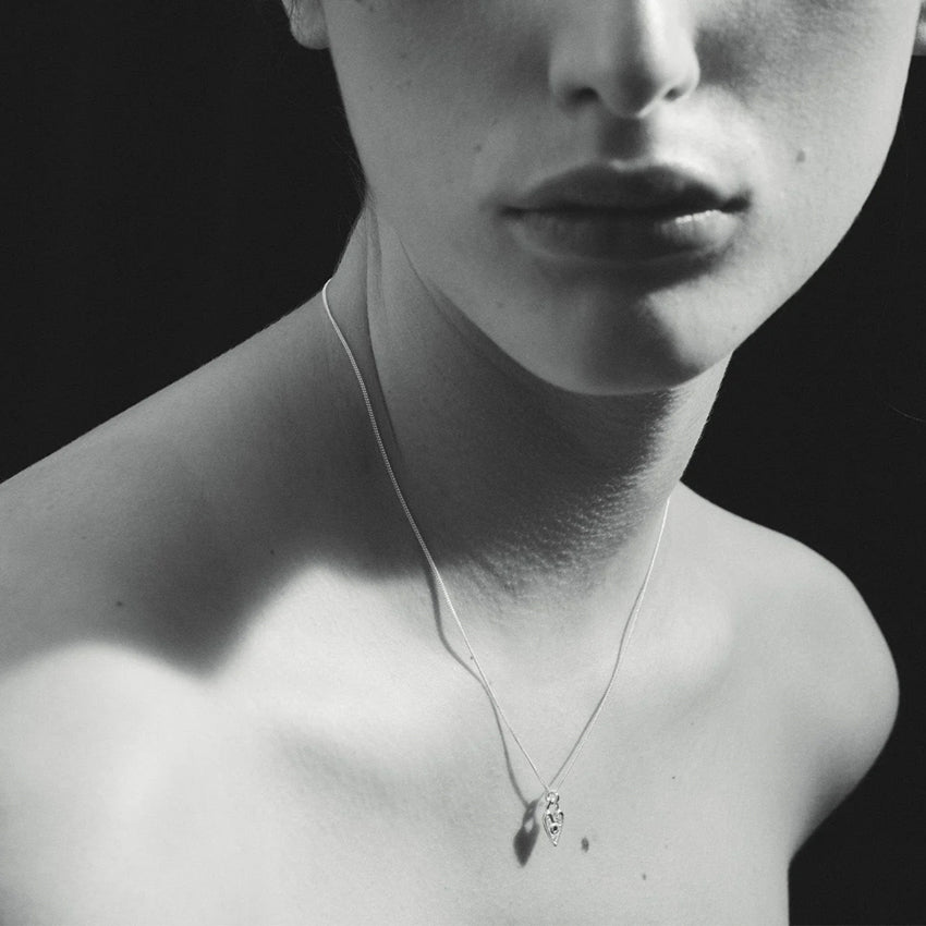 The Temple Of The Sun Amore Necklace in Sterling Silver on a model in black and white