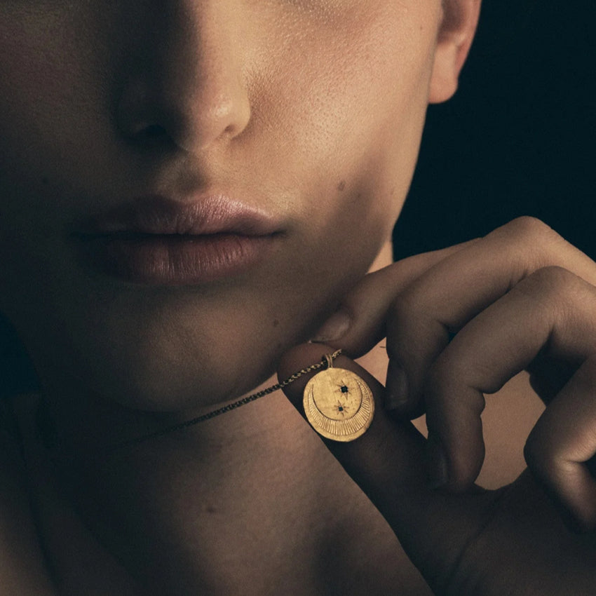 The Temple Of The Sun Celeste Necklace in Gold on a model with her holding it