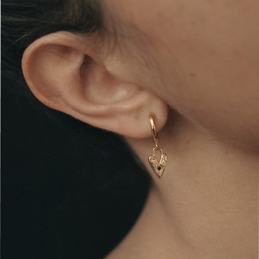 The Temple Of The Sun Lover Earrings in Gold on a models ear