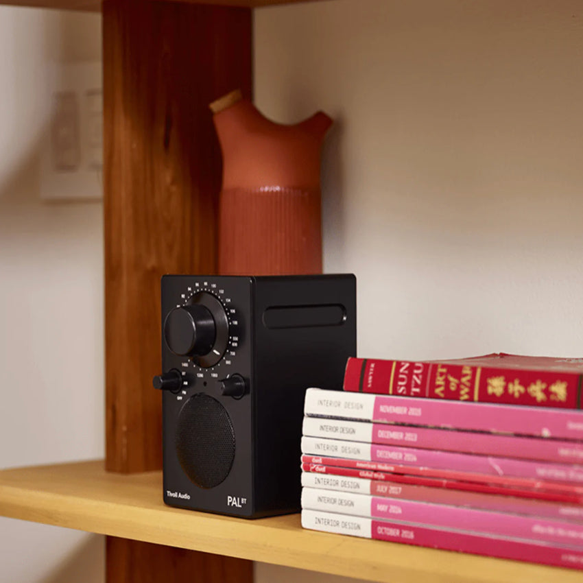 The Tivoli Audio PAL Bluetooth Radio in Black on a bookshelf