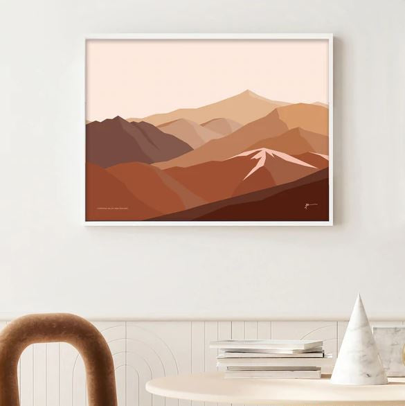 A digital art print depicting the Cardrona Valley landscape with shades of brown by Bridget Hall in a frame on a wall