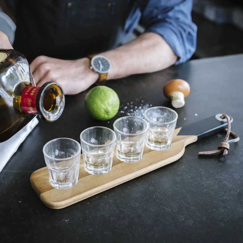 Gentlemen's Hardware Serving Paddle in action with tequila being poured into the shots glasses and lime and salt on the side