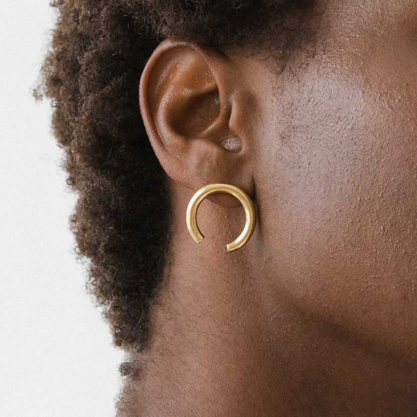 The Nina Gordon Isa Earrings in Gold on a model