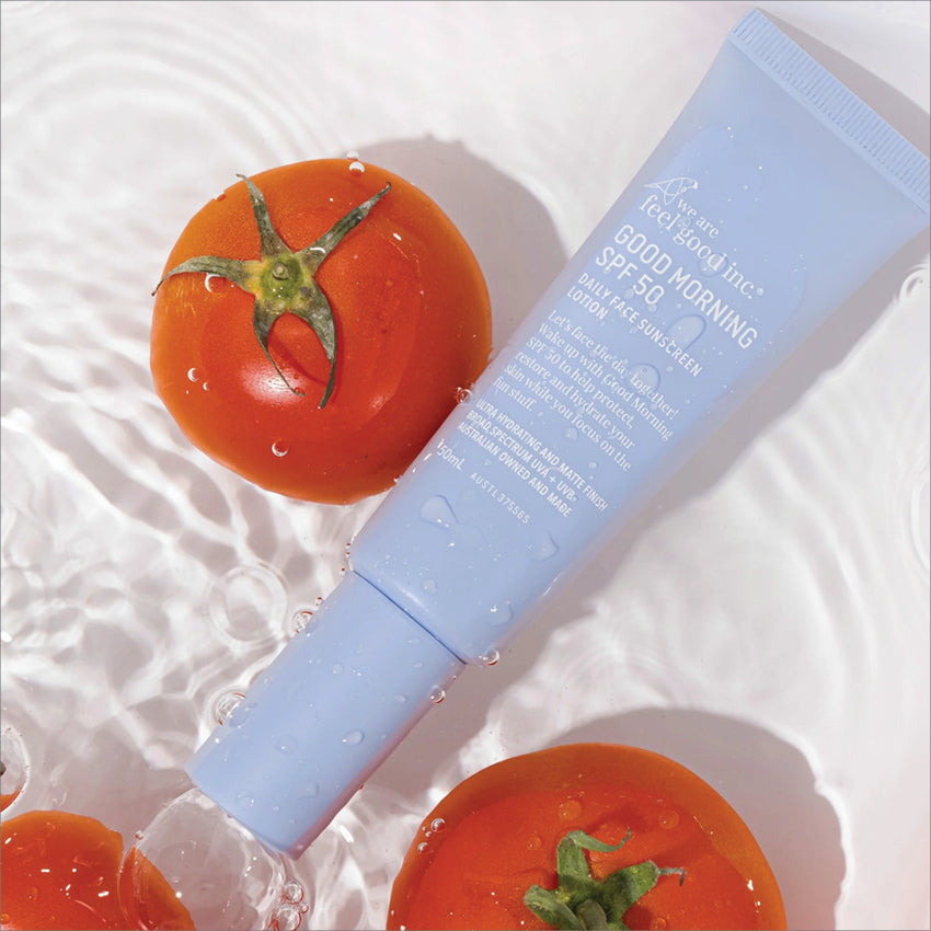 The We Are Feel Good Inc Good Morning SPF 50 Face Sunscreen tube in water with tomatoes