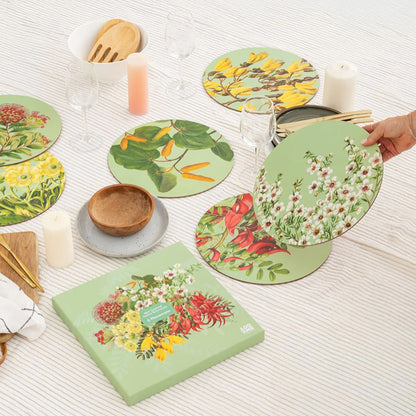 Set of NZ Native Botanical patterned placemats on a table with candles and serveware.