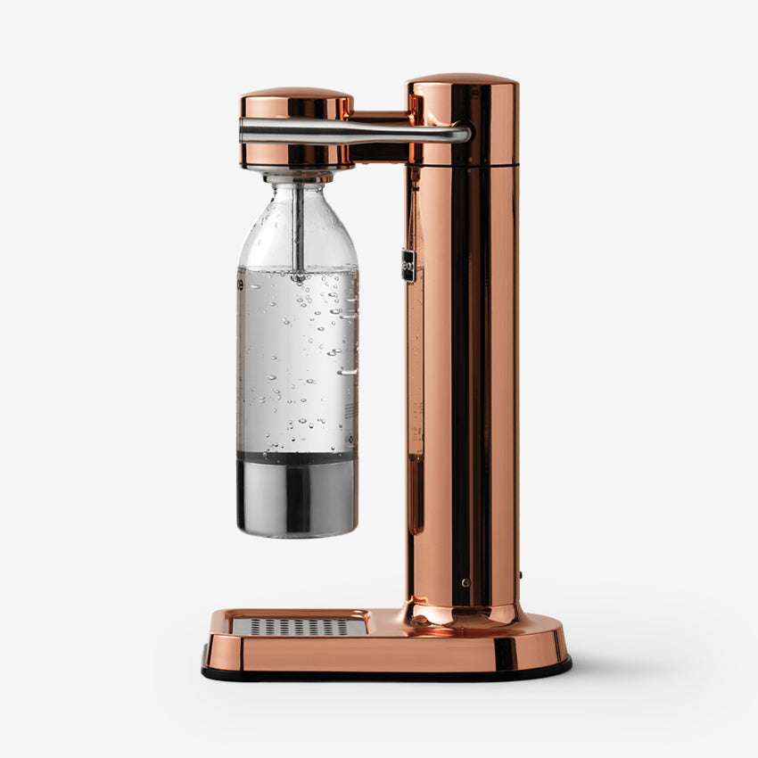 The side profile of the Aarke Carbonator 3 in Copper with the PET water bottle on a blank background