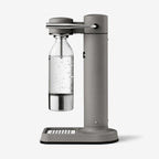 The Aarke Carbonator 3 in Matte Grey with a PET water bottle on a blank background
