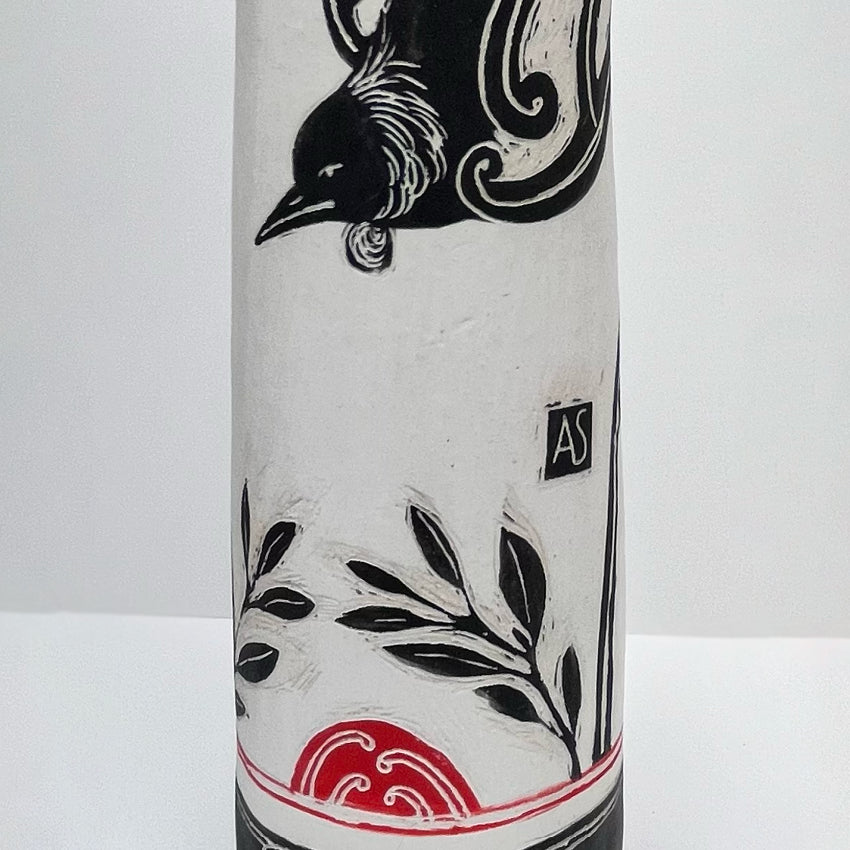 A closeup of the Amber Smith Kia Kaha Tui Tall Vessel on a blank background