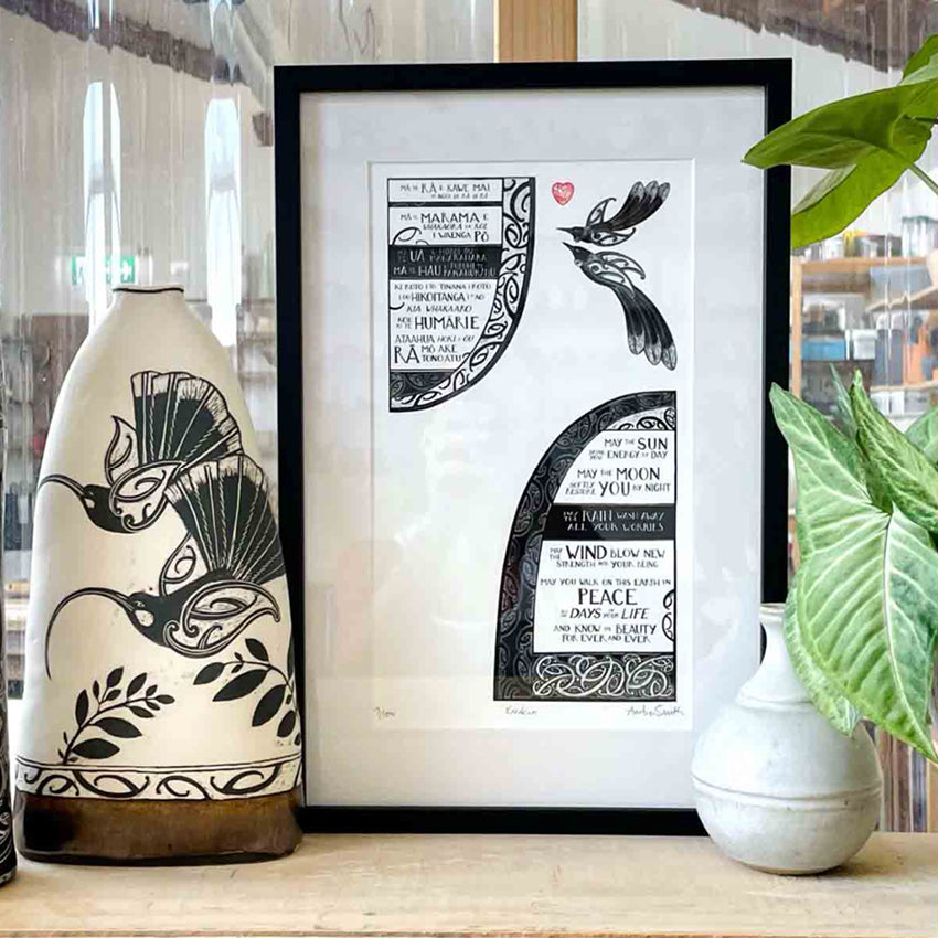 The Amber Smith Karakia Print in a frame on a shelf