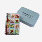 The Anoint Rose Geranium Lotion Bar next to its tin on a blank background