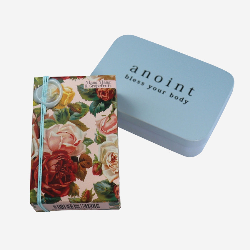 The Anoint Ylang Ylang and Grapefruit Lotion bar with tin on a blank background