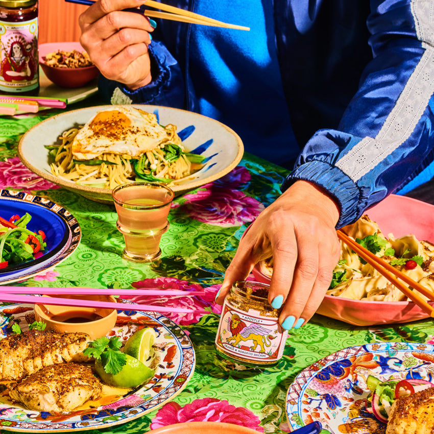 The Apostle Orange and Horopito Seasoning jar being put on a table surroned by food
