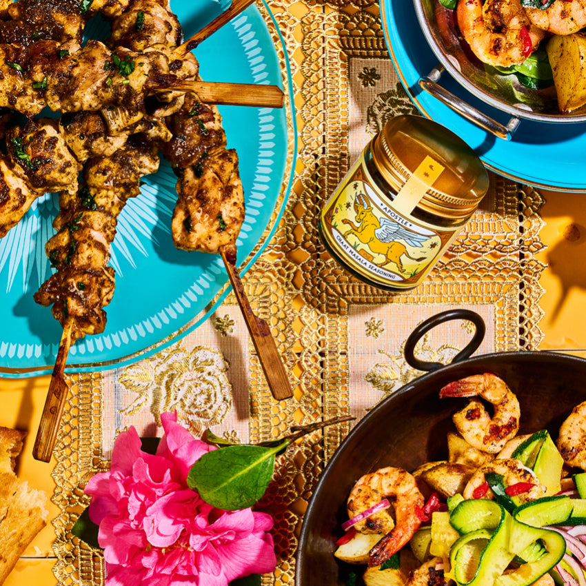 The Apostle Chaat Masala Seasoning jar on a table next to cooked dishes
