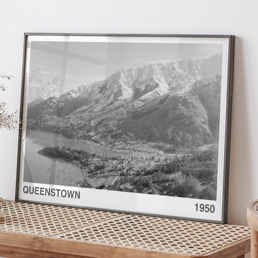 The ARTORY Queenstown 1950 Art Print in a black frame on a bench
