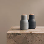 The Small Audo Salt and Pepper Grinder in Blues and Beech on a bench