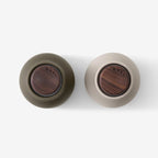 A top view of the small Audo Salt and Pepper Grinder in Hunting Green and Walnut on a blank background