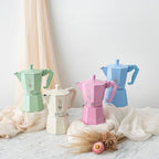 Four of the Bialetti 6 cup size Moka Exclusive Coffee Makers in pastel colours in a styled shot