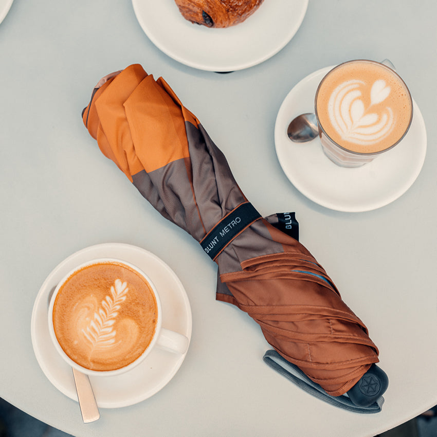 The closed Blunt Metro Umbrella in Limited Edition Gingerbread on a table