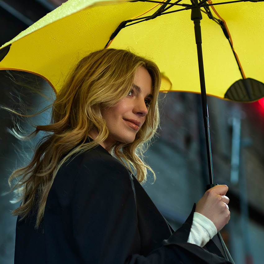 The Blunt Metro Umbrella in Yellow with a model holding it