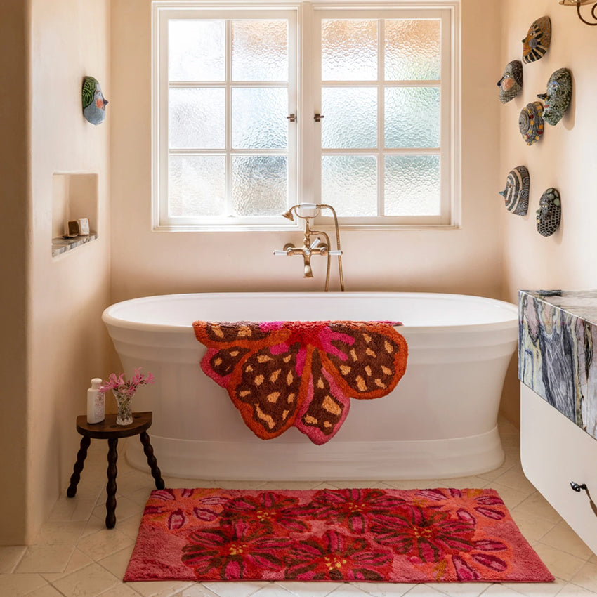 Bonnie and Neil Long Candy Pink  Bath Mat on a bathroom floor next to a bath