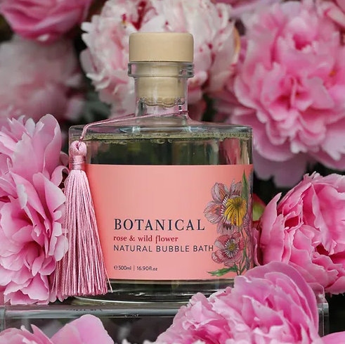 The Botanical Rose and Wild Flower Natural Bubble Bath surrounded with flowers
