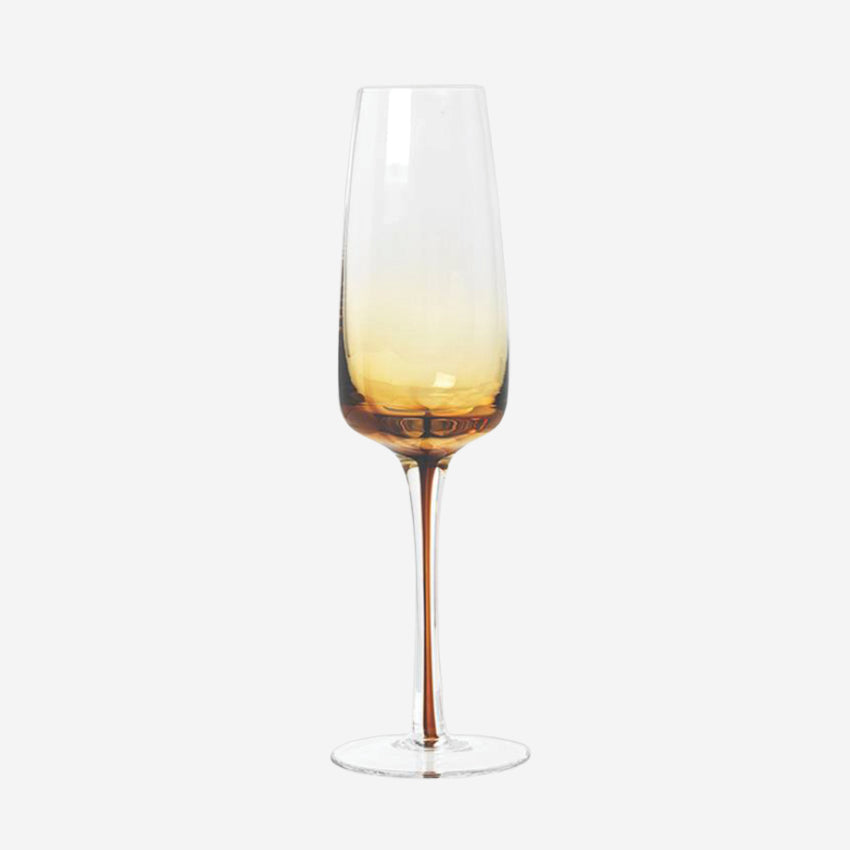 The Broste Copenhagen Champagne Glass in Amber on a blank background