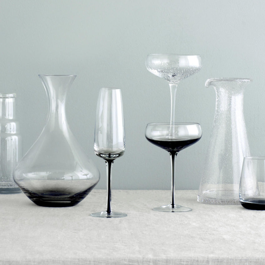 The Broste Copenhagen Cocktail Glass in Smoke alongside other glassware