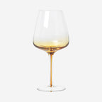 The Broste Copenhagen Red Wine Glass in Amber on a blank background