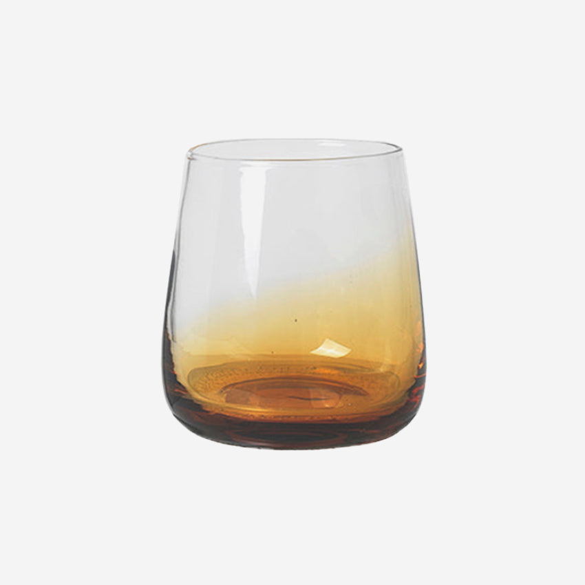 The Broste Copenhagen Short Tumbler Glass in Amber on a blank background