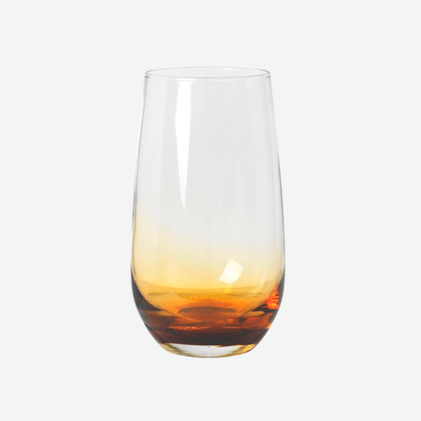 The Broste Copenhagen Tall Tumbler Glass in Amber on a blank background