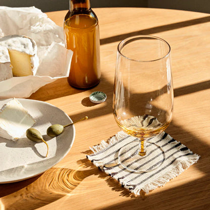 The Broste Copenhagen Beer Glass in Amber on a table with cheese