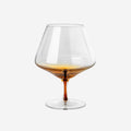 The Broste Copenhagen Cognac Glass in Amber on a blank background