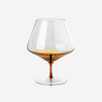 The Broste Copenhagen Cognac Glass in Amber on a blank background