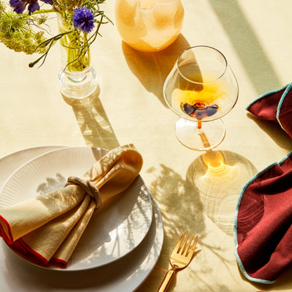 The Broste Copenhagen Cognac Glass in Amber on a table setting