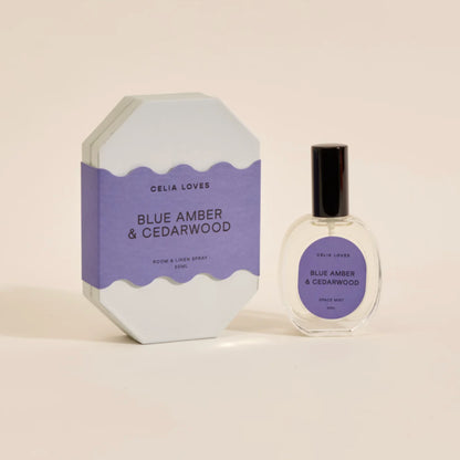 The Celia Loves Blue Amber and Cedarwood Room and Linen Spray with it's box on a blank background