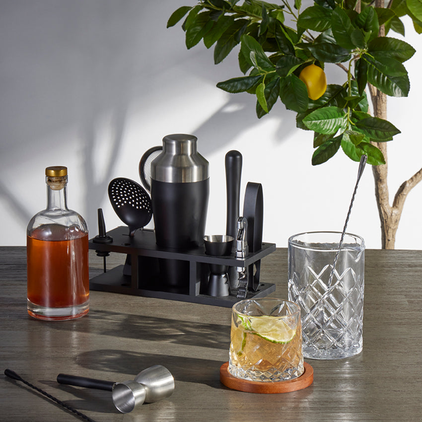 The Davis & Waddell Bar Set with Stand on a bench top with drinks and a lemon tree