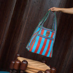 The EAU Sac Bag in Club Rouge being held up over a stool