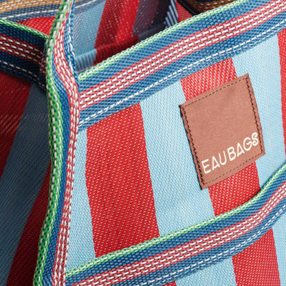 A close up of the EAU Sac Bag in Club Rouge on a grey background