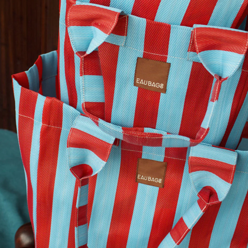 Three of the EAU Bags in Club Rouge stacked on top of each other