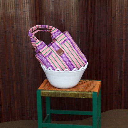 The EAU Tote Bag in Wild Clay sitting in a bowl on a stool